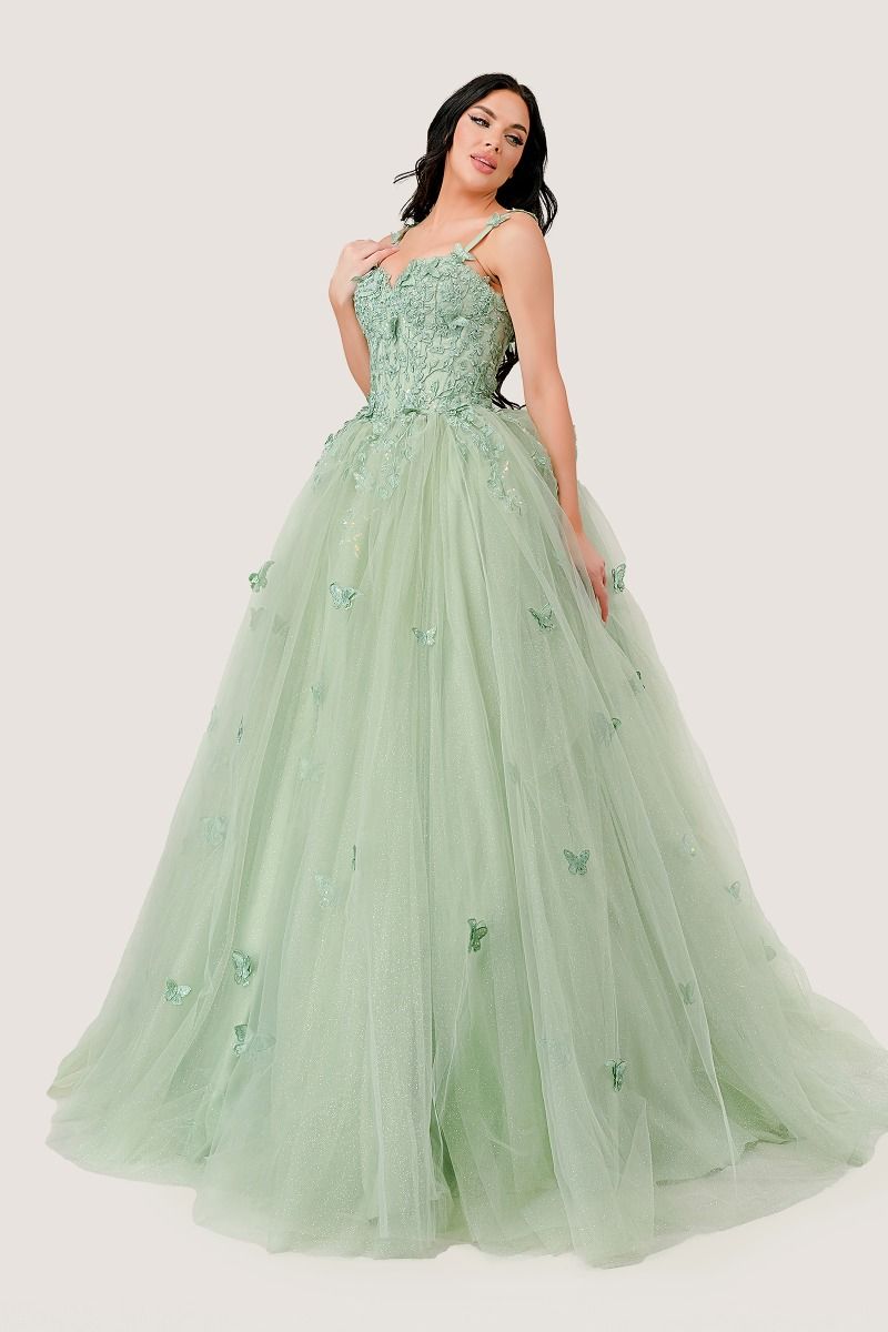 A woman stands against a plain background wearing the Light Green Quinceanera Dress 15718 by Ladivine, featuring floral embroidery and a pastel tulle skirt.